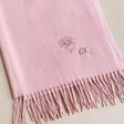 Close up of personalisation on Personalised Birth Flower Pink Winter Scarf against neutral background