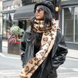 Lifestyle shot of model wearing Leopard Print Winter Scarf with sunglasses on and hands in pocket