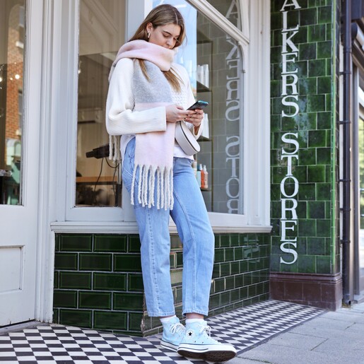 Lifestyle shot of Light Pink and Grey Striped Winter Scarf on model on phone