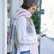 Light Pink and Grey Striped Winter Scarf on model in lifestyle shot on phone
