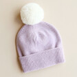 Lilac and Cream Pom Pom Bobble Hat on Beige Surface