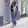 Lifestyle shot of Mustard and Blue Tartan Winter Scarf on model walking through street with green bag