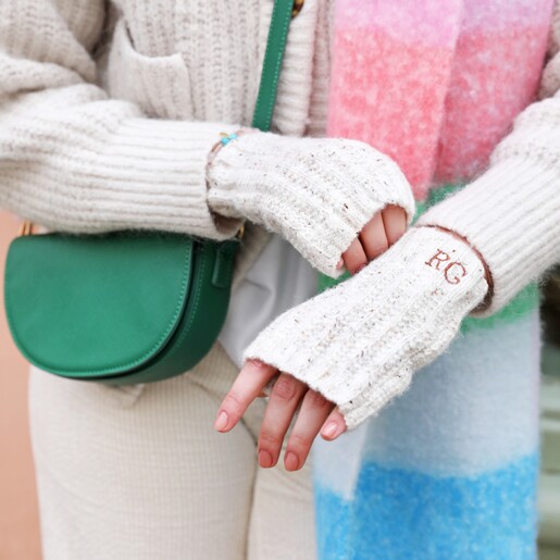 Model Wearing Hand Warmers Model wearing Personalised Embroidered Knitted Hand Warmers in Marled Cream with pastel bright scarf and green crossbody bag
