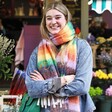 Model smiling wearing Personalised Vibrant Rainbow Striped Winter Scarf with arms crossed