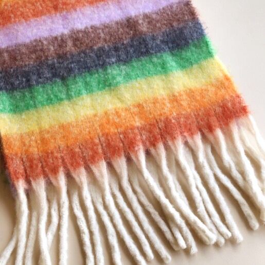 Close up of Vibrant Rainbow Striped Winter Scarf against neutral background
