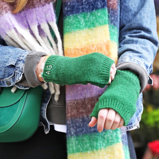 Close up of Vibrant Rainbow Striped Winter Scarf on model wearing green hand warmers