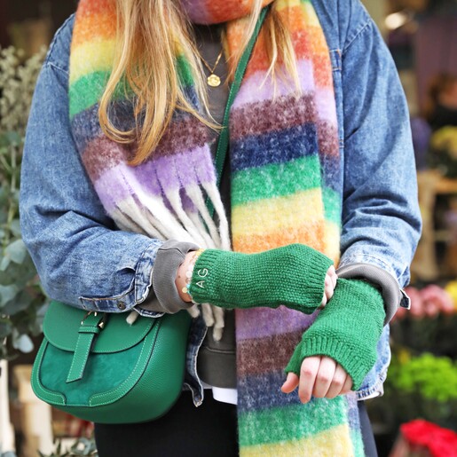 Vibrant Rainbow Striped Winter Scarf on model wearing green hand warmers and crossbody bag