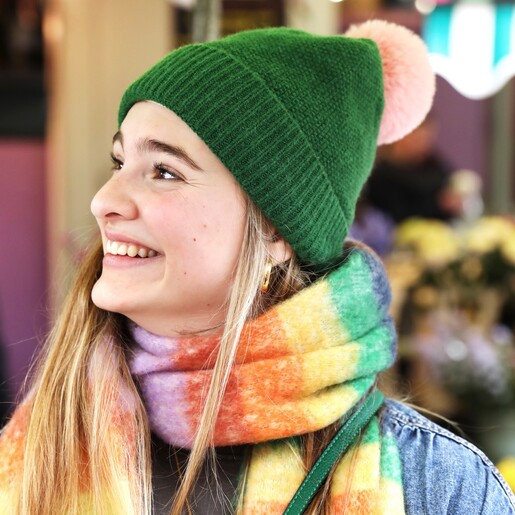 Vibrant Rainbow Striped Winter Scarf on model wearing green bobble hat