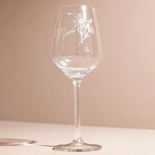 Empty Personalised Birth Flower Wine Glass against pink background