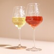 Two Personalised Birth Flower Wine Glass against pink background