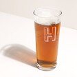 Personalised Bold Initial Pint Glass with beer on a white background