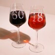 Personalised Floral Milestone Birthday Wine Glasses with 18 and 60 personalisation on beige surface