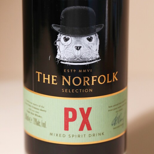 Close Up Close up of front of 500ml The English Distillery Norfolk PX Mixed Spirit Liqueur bottle against beige backdrop