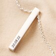 Close up of Personalised Sterling Silver Bar Necklace on top of beige coloured fabric