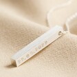 Personalised Bar Pendant Necklace in Silver with hand stamping on top of beige coloured fabric