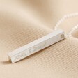 Personalised Bar Pendant Necklace in Silver with clean engraving on top of beige coloured fabric
