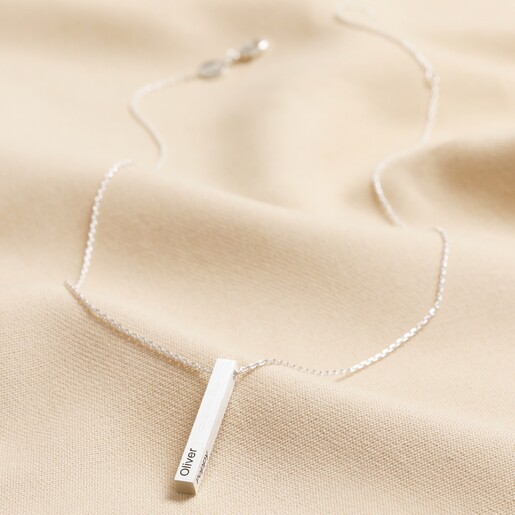 Personalised Bar Pendant Necklace in Silver on top of beige coloured fabric full length