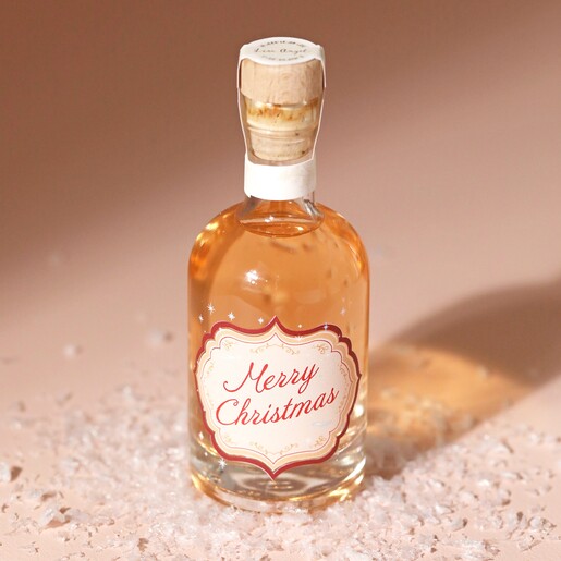 100ml Merry Christmas Spiced Gin on top of neutral backdrop with fake snow 