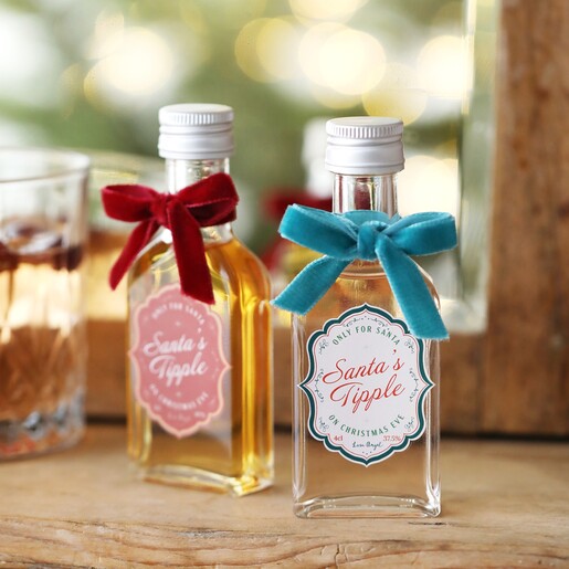 40ml Santa's Tipple Christmas Spiced Gin with Christmas whisky on top of wooden counter with glass beside