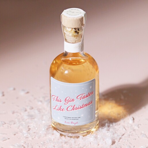 100ml Tastes Like Christmas Spiced Gin on top of beige surface with fake snow