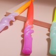 Close up of Pink Stories Colour Pop Dip Dye Swirl Candles out of packaging against neutral coloured backdrop