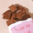 Love You To The North Pole Milk Chocolate Bar broken into chunks against neutral background