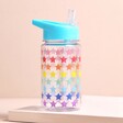 Sass & Belle Children's Rainbow Stars Water Bottle on top of beige surface with neutral backdrop