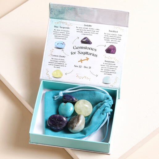 Sagittarius Zodiac Gemstone Set open with gemstones inside on top of blue bag