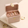 Embroidered Flowers Petite Travel Ring Box Open with Jewellery Inside on Beige Surface