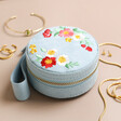 Embroidered Flowers Mini Round Jewellery Case on Beige Surface 