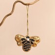 Bee Beaded Hanging Decoration hanging on branch against beige background