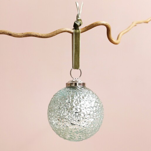 Floral Debossed Mint Green Bauble Hanging Against Pink Background