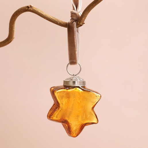 Gold Star Bauble Hanging on a pink background
