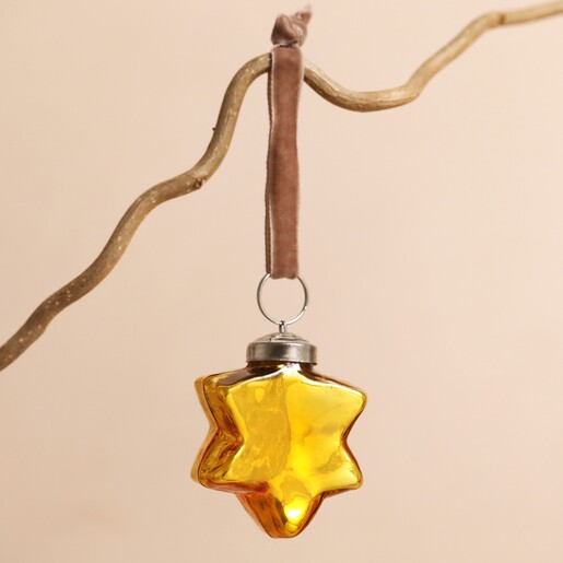 Gold Star Bauble Hanging on a Branch on a Pink Background