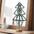 Green Woven Rope Tree Ornament in Front of Mirror