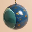 Side of Hand-Painted Winter Moon Bauble hanging against beige background