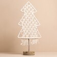 White Woven Rope Tree Ornament Against Pink Background