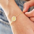 Close Up of Crystal Edge Disc Bracelet in Gold on Model's Wrist
