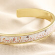 Close up of Pink Floral Bee Enamel Bangle in Gold on top of beige coloured material