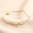 Infinity Charm Bracelet in Gold on Beige Fabric
