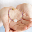 Model holding Purple Crystal and Pearl Beaded Bracelet in palm of hand
