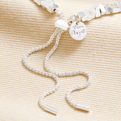 Close up of clasp on Rectangular Beaded Bracelet in Silver against beige coloured material