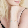 Semi-Precious Healing Stones Charm Bracelet in Gold on Model Resting Her Chin on Her Hand