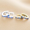 Blue Baguette Crystal Huggie Hoops in Gold stacked next to silver version