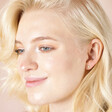 Blonde model looking down wearing Set of Four Crystal Celestial Stud Earrings in Gold