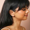 Model looking to side wearing Set of Four Crystal Celestial Stud Earrings in Silver