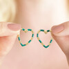 Green Enamel Striped Heart Hoop Earrings in Gold Held Between Fingers by Model