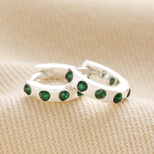 Huggies from Set of 2 Green Crystal Huggie and Hoop Earrings in Silver on top of beige coloured fabric