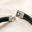 Close up of clasp on Men's Leather Fishtail Bracelet in Grey on top of beige fabric