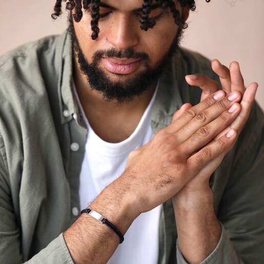 Men's Leather Fishtail Bracelet in Black on model with hands together looking down